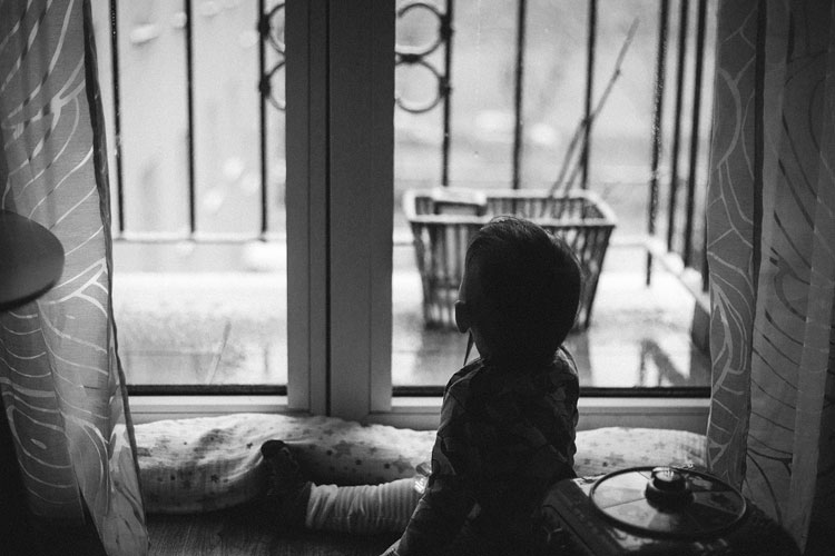 Mała dziewczynka wyglądająca przez okno w czasie kwarantanny. Zostań w domu